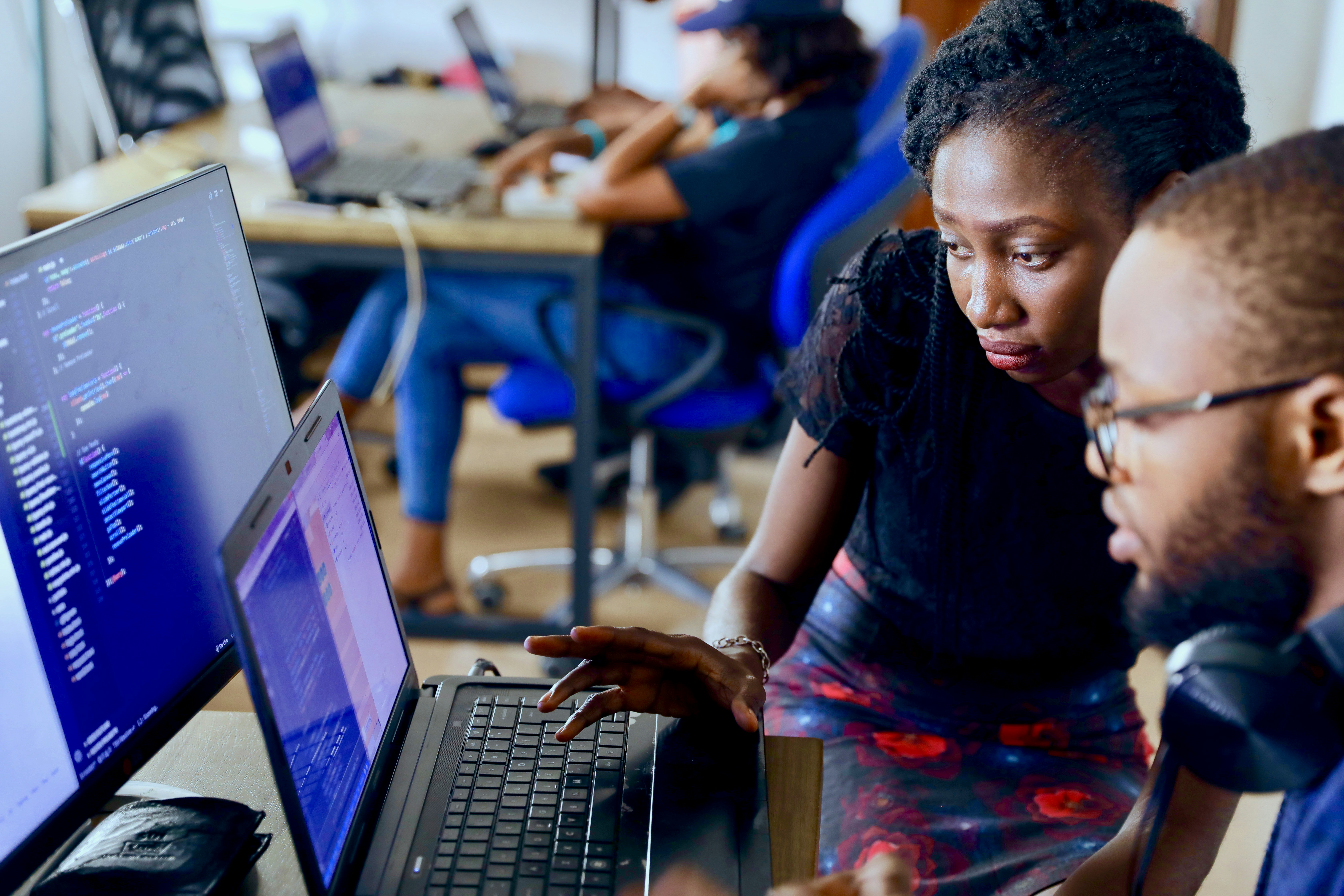 A man and a women looking at a computer together