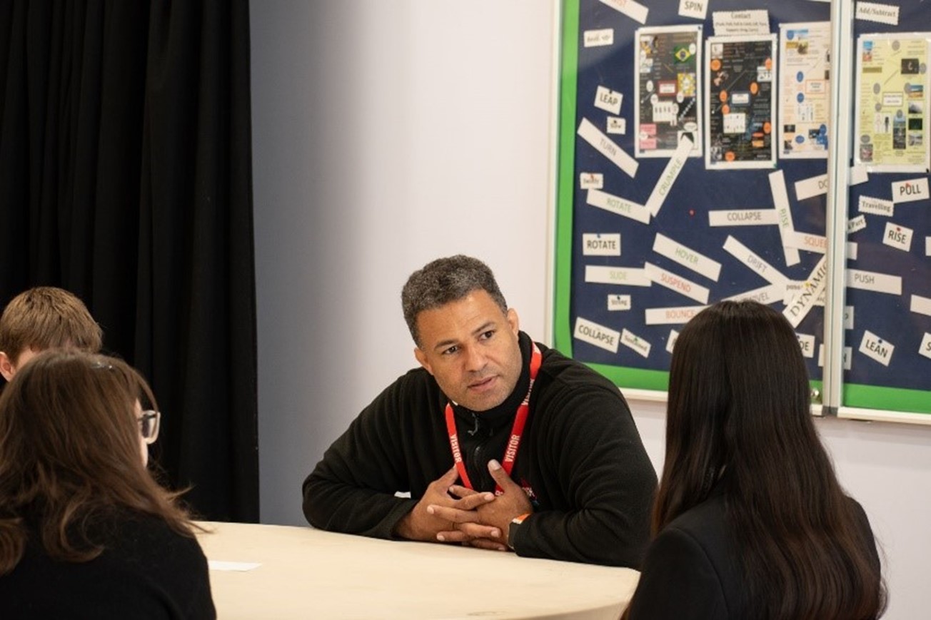 Photo: A volunteer speaking to students at a school event