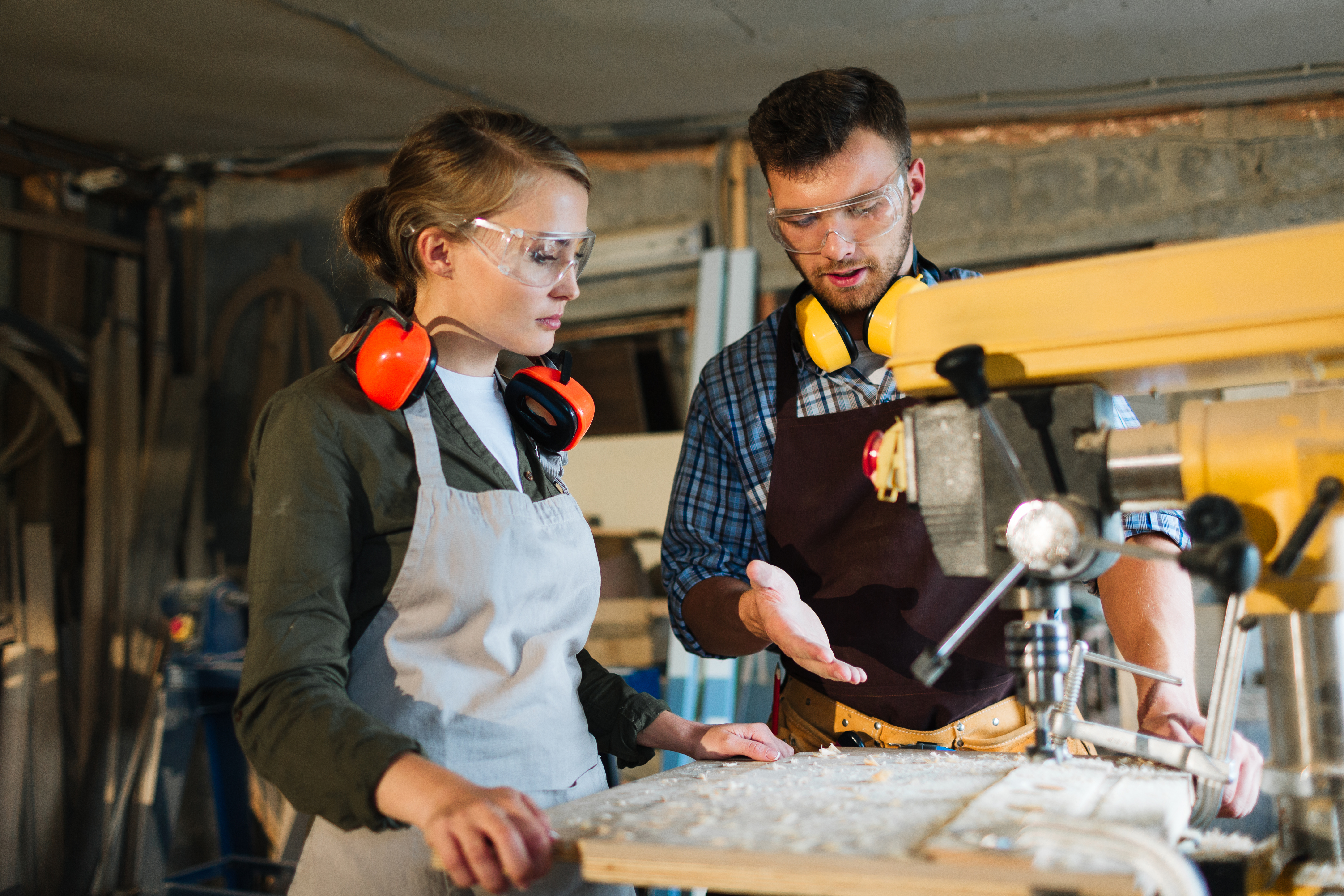 Male and female in a workshop looking at a machine