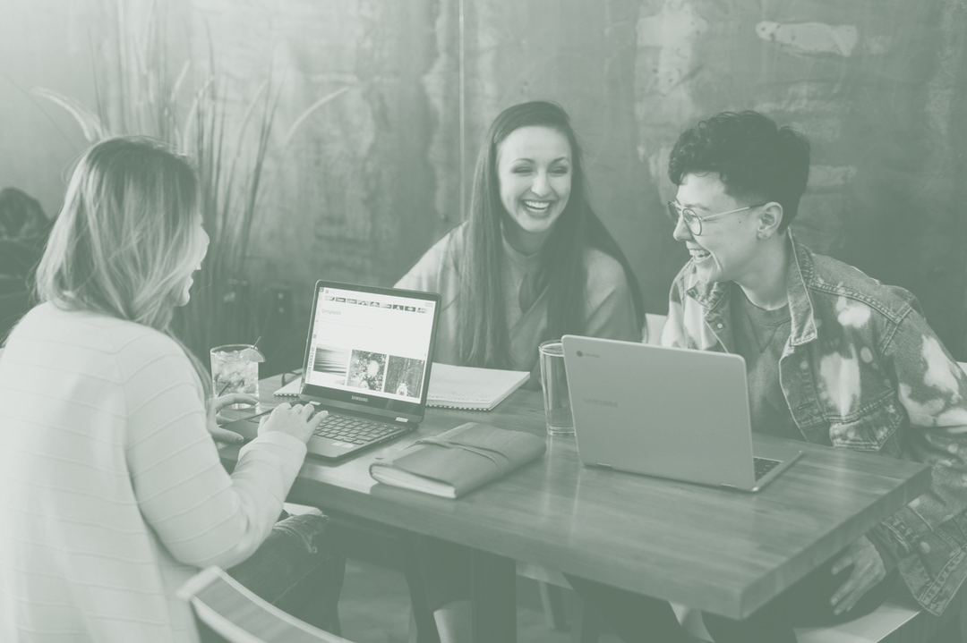 Group Smiling while working on Laptops