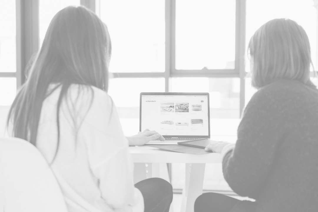 Two Women Looking At Laptop