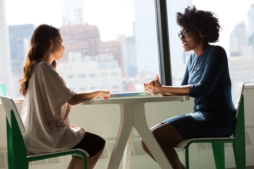 Two Women Sat Opposite Each Other At Table