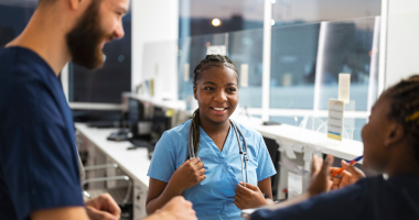 Female nurse with stethoscope talking to collegues 