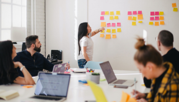 group young colleagues meeting in workplace using sticky notes