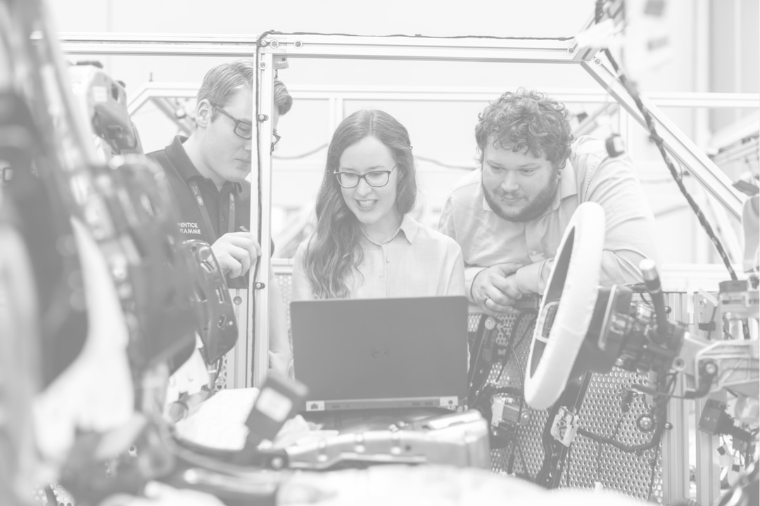 Engineers looking at a laptop while Working On Vehicle