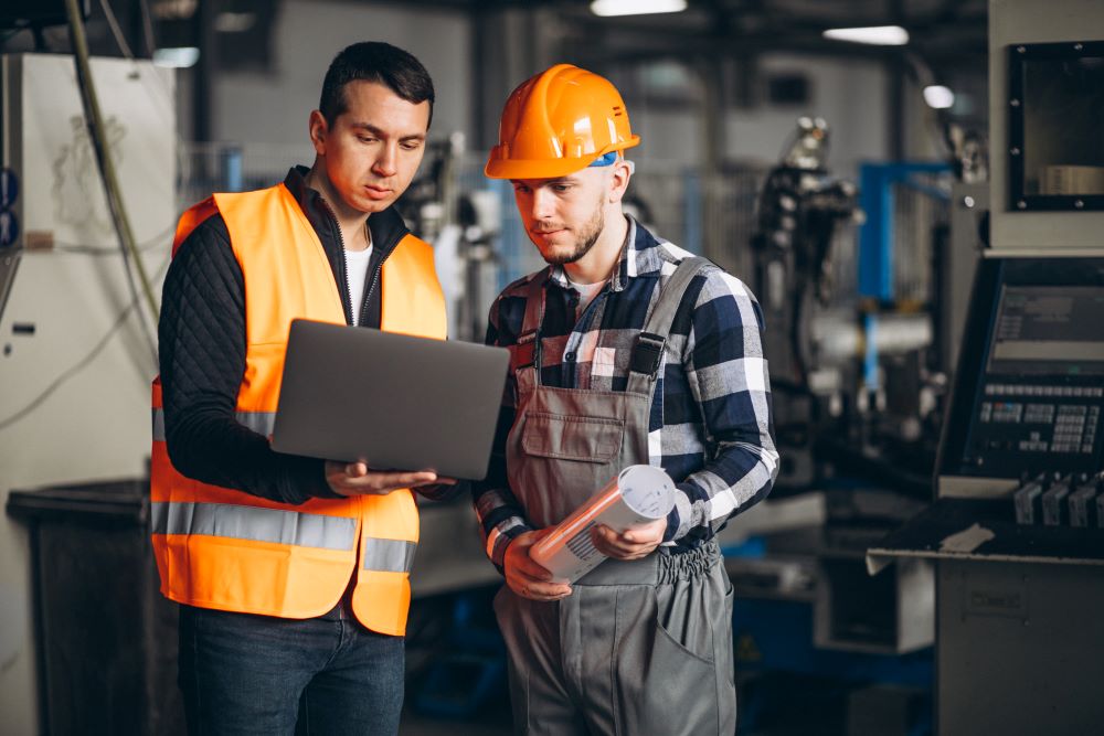 Two colleagues in a factory looking at a computer 