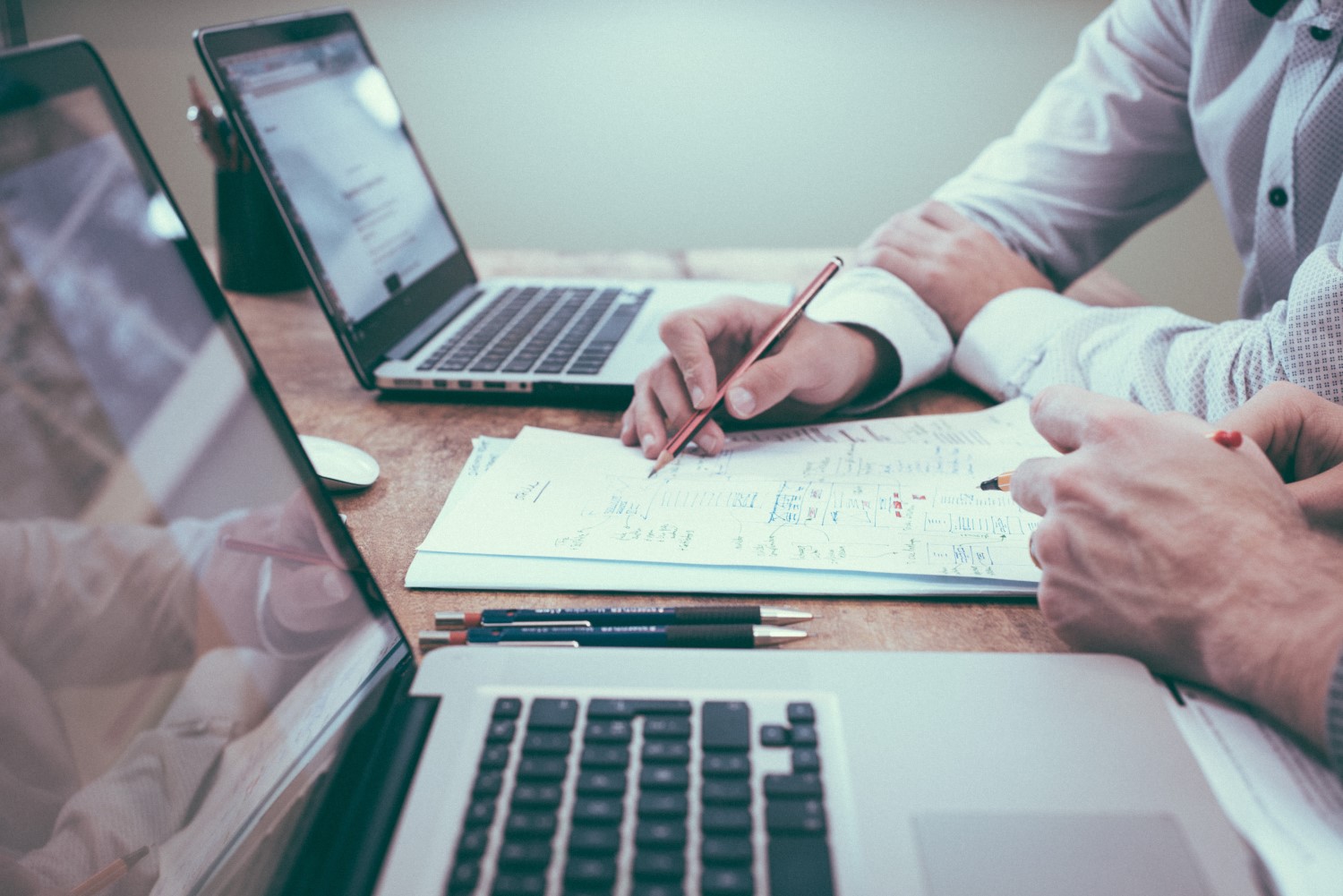 business people discussing over document with laptop on table at office