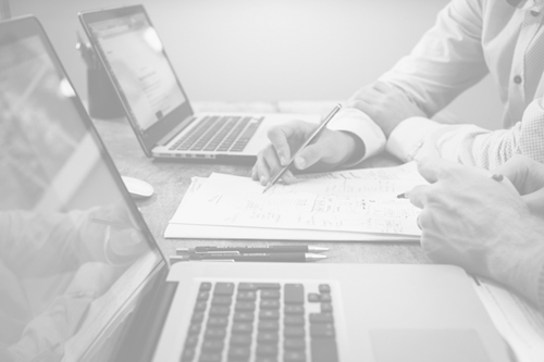 business people discussing over document with laptop on table at office